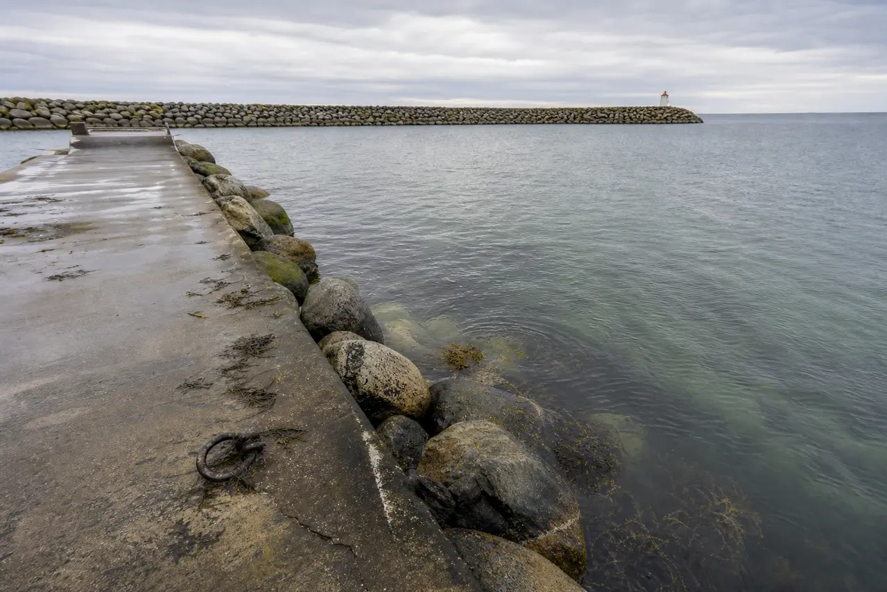 Havnemole med sten, tang og dybt vand